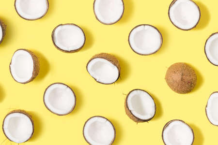 Fresh organic coconut pattern on bright yellow background. Flat lay.