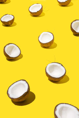 Fresh organic coconut pattern in perspective on bright yellow background.