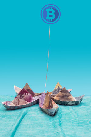 Symbol of bitcoin tight up with blockchain five paper bank notes boat shapes. Cryptocurrency...