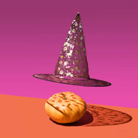 Halloween concept made of striking black with golden glitter prints levitating witch hat and fresh...