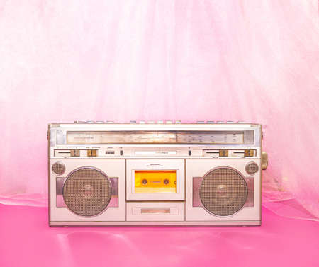 Retro music concept with silver cassette player against pink and purple background.の写真素材