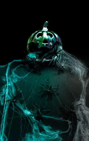 Halloween pumpkin scary minimal futuristic arrangement. Spiders crawling on terrifying web. Creepy dark backgroundの写真素材