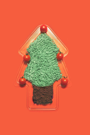 Joyful healthy vegetarian eats concept. Tree look like shape dish with green noodles in it and fresh cherry tomato. Flat lay arrangementの写真素材