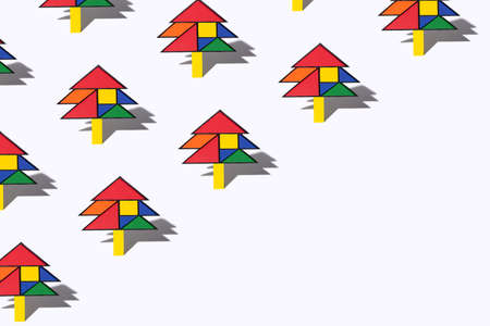 Abstract modern christmas tree inspired concept. Pattern made of minimalist Mondrian style christmas tree created of tangram puzzles arrangement against snow white background. Creative copy space..の写真素材