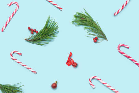 Christmas inspired beautiful pattern. Pattern made of red and white candy canes, pine trees , red berries, little decoration on pastel blue pinkの写真素材