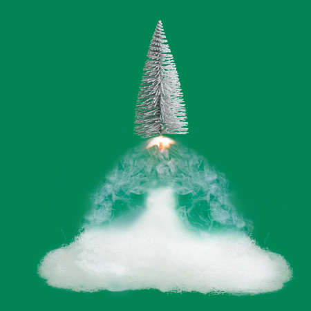 Christmas tree launch at New Year winter inspired concept. Minimal green background.の写真素材