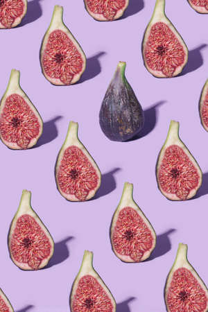Minimal pattern arrangement of fresh organic halves of purple organic yummy fig fruit . Vibrant purple backgroundの写真素材