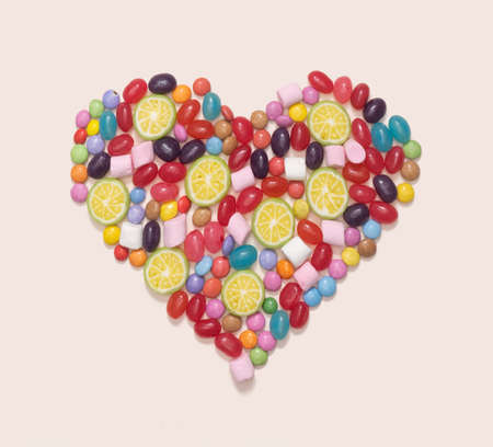 Sweet romantic minimal concept. Heart made of many different jelly beans and candies against...