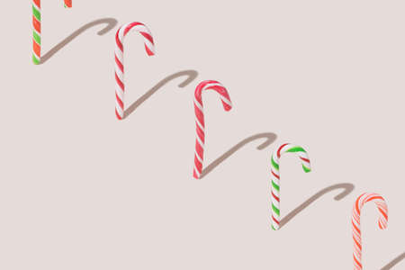 Diagonal line made of different types and tastes standing alone candy canes. Creative copy space against beige backgroundの写真素材