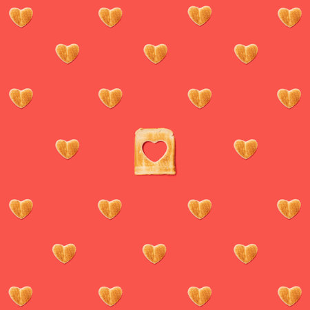 Love concept. Pattern made of many heart shaped toasts and one slice of toasted bread with a heart...