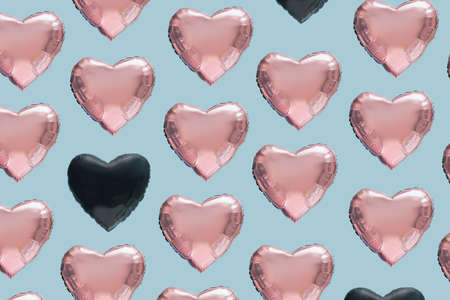 Pattern created of many pink heart and two black heart shaped balloons.  Blue background. Diversity...