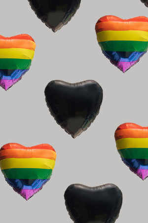Pattern created of many rainbow and black heart shaped balloons.  Gray background. Diversity, LGBT and black lives matters abstract concept.の写真素材