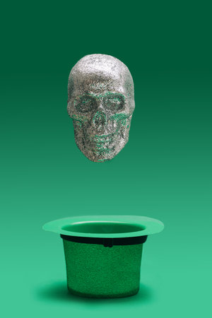 Modern abstract death-s-head minimal concept. Silver glitter skull levitate above green top hat. Nice green background.の写真素材