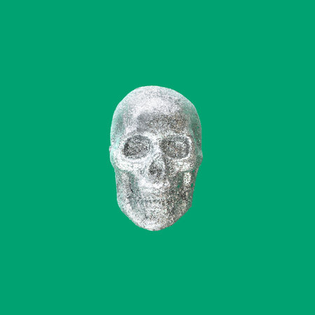Minimal abstract dead and mortality concept. Shine silver, glitter skull levitate against fresh green backgroundの写真素材