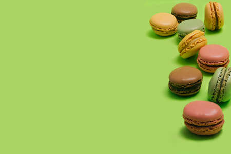 Optimistic artisan love the patisserie concept. Many different color and taste macarons with large copy space at left. Bright green backgroundの写真素材