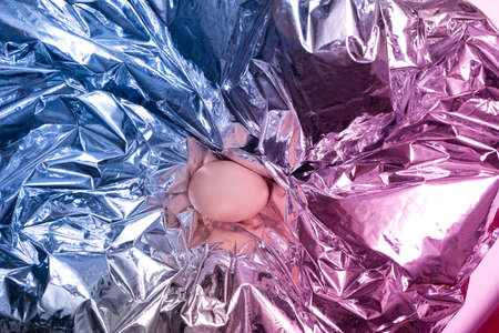 Futuristic minimal Easter concept. Flat lay arranged with free range egg against a cyber punk red and blue awesome background.の写真素材