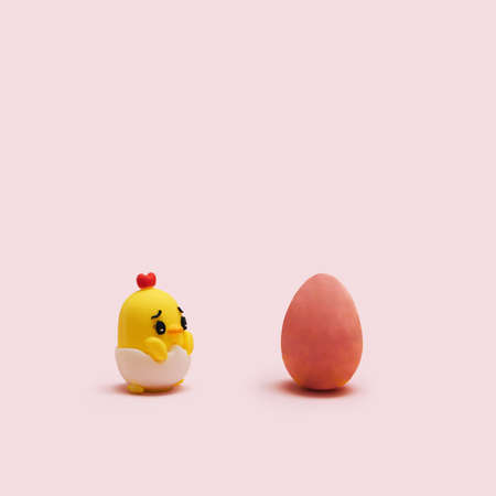Awesome minimal Easter concept.  Little chick toy with one red egg arrangement with creative copy space. Pastel pink background.の写真素材