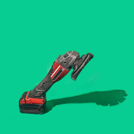 A brushless cordless Angle Grinder on beautiful green background with sunny shadow