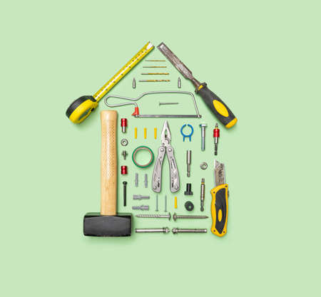 Arrangement of disc from circular saw, hammer, meter, stainless multi pliers. scalpel, tool kits, screwdrivers, and other tools with on pastel green background. Top view.の写真素材