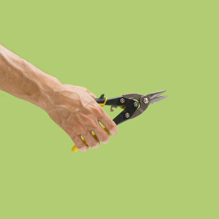 Man hand holding straight cut pliers suitable for cutting plastic or metal  material on light green color background. Aviation snips.の写真素材