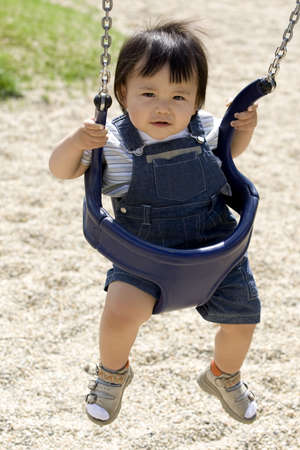 Baby on a swing in a parkの写真素材
