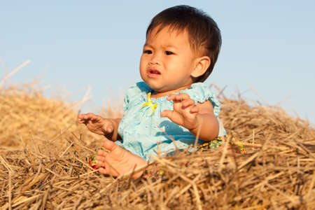 Baby of Asia sits on strawの写真素材