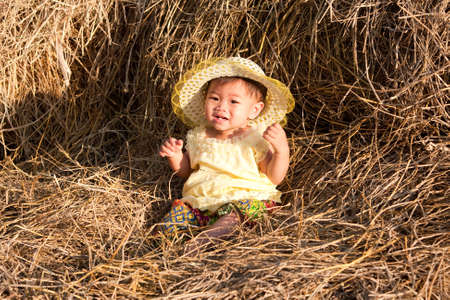 Baby of Asia sits in strawの写真素材