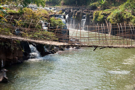 suspension bridge at water fall in Tat Fane, Province Paksong, Laosの写真素材