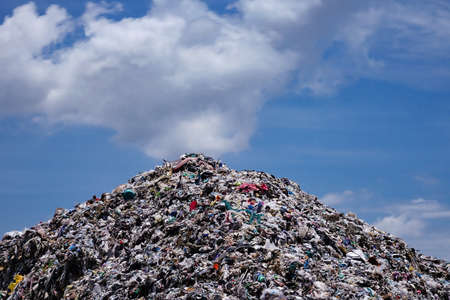 Landfill with blue sky and cumulus cloudsの写真素材