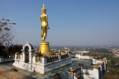giant golden buddhist figurine on Khao Noi hill looking to Nan Cityの写真素材