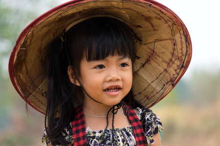 Four year old cute girl with vietnamese hatの写真素材