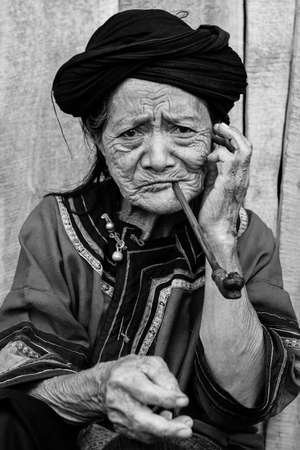 Portrait of old hill tribe woman smoking pipeのeditorial素材