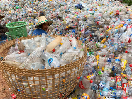 Ban Na Namchum, Thailand - May 10, 2019: Thai workers clean empty plastic bottles with hand for recycling by factoryのeditorial素材