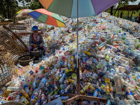 Ban Na Namchum, Thailand - December 1, 2019: Asian worker clean empty plastic bottles by hand. The cleaned plastic bottles are melted down and reused.のeditorial素材