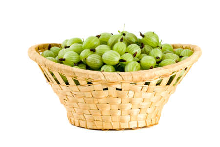 Wicker basket filled with green gooseberries isolated on the white backgroundの写真素材