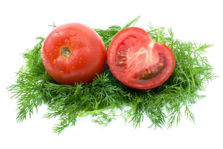Whole and half of tomato over some dill isolated on the white backgroundの写真素材
