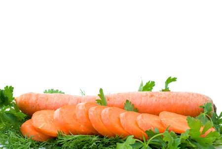 Ripe fresh long carrot and slices over some parsley isolated on the white background (focused on carrot slices)の写真素材