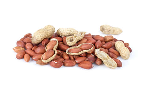 Some whole, shelled roasted peanuts and husk isolated on the white background