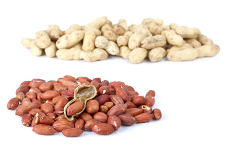 Shelled roasted peanuts and some husk isolated on the white background
