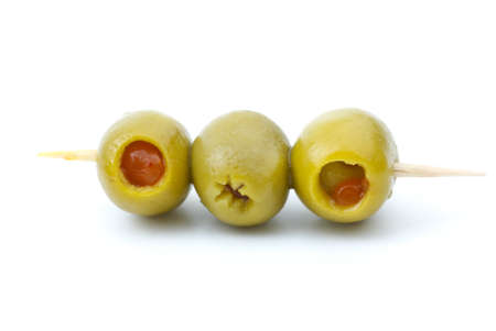 Some olives stuffed with pepper on a wooden toothpick isolated on the white backgroundの写真素材