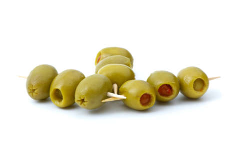 Some olives stuffed with pepper on a wooden toothpicks isolated on the white backgroundの写真素材