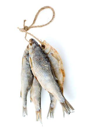 Five dried sea roach fishes on the rope isolated on the white backgroundの写真素材