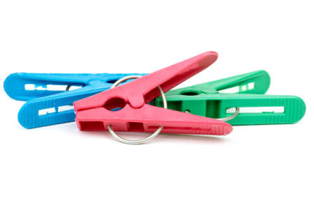 Three cheap plastic clotespins isolated on the white background