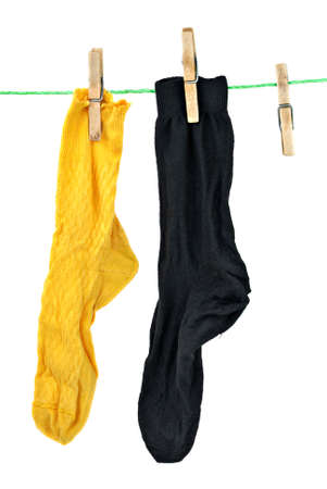 Yellow and black socks hanging on rope isolated on the white backgroundの写真素材