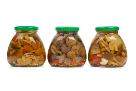 Three glass jars with marinated mushrooms isolated on the white backgroundの写真素材