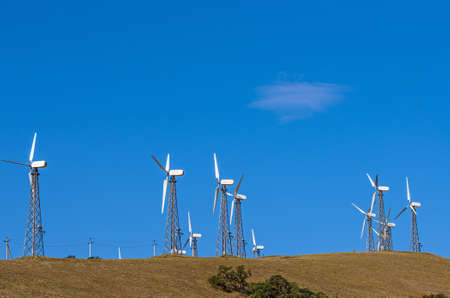 Wind turbine towers over the blue sky