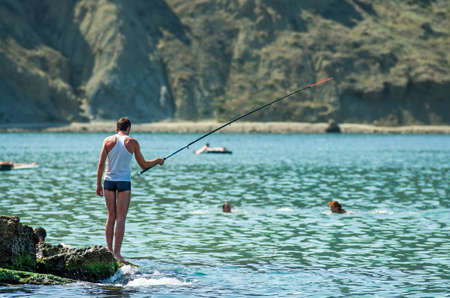 Man trying to catch fish with fishing rod