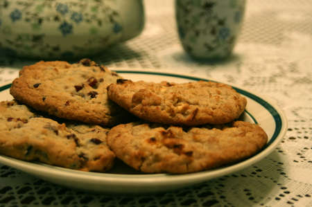 cookies on a plate with a teapot and cup in the background