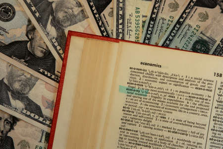 dictionary with economy highlighted with money backgroundの写真素材