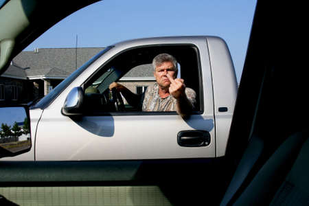 man showing middle finger in anger to another driver